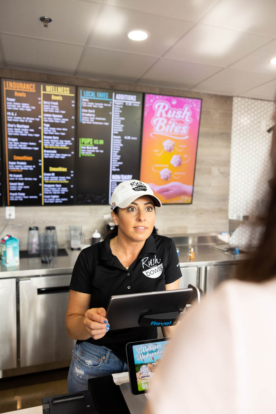 A Rush Bowls worker helping costumers choose and order their favorite flavors from our amazing menu!