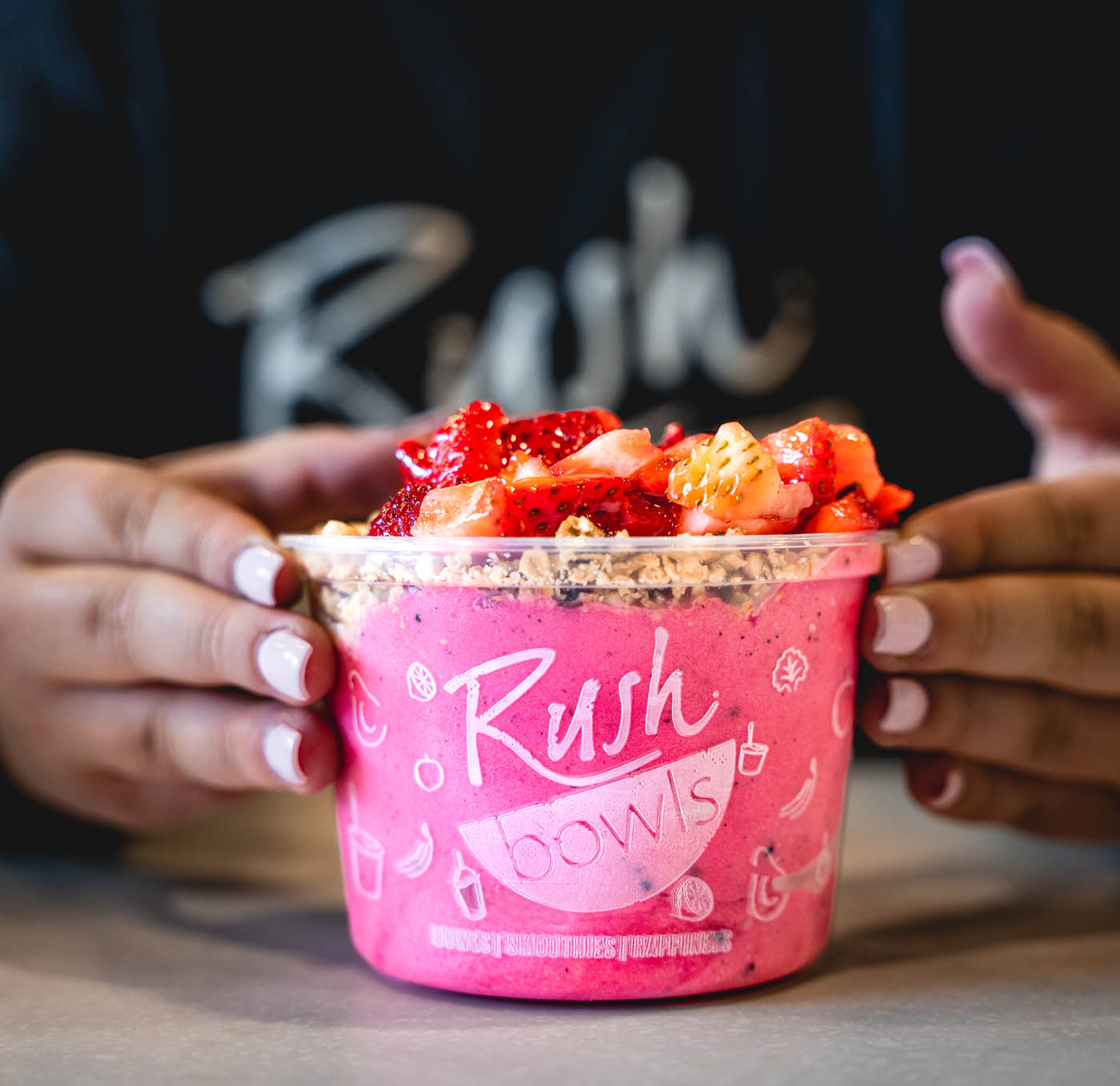 A girl enjoying a Rush Bowls - enjoy yummy food and retirement security with Rush Bowls' franchise pros.
