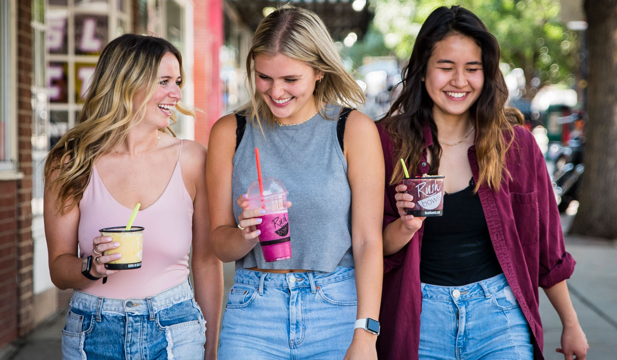These three young women sip on Rush Bowls smoothies and are consistent customers in the health food industry.