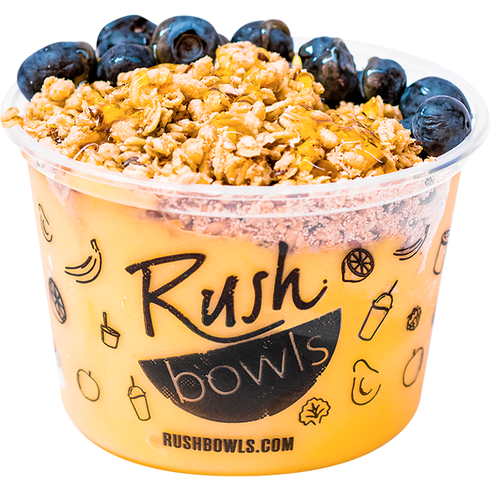 Granola, blueberry, and honey toppers on a yellow smoothie bowl.